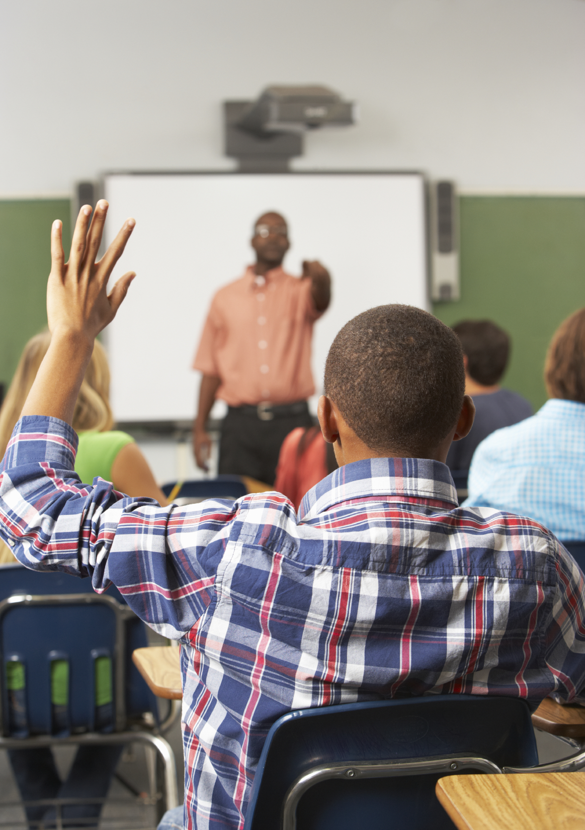 Male Pupil Raising Hand In Class